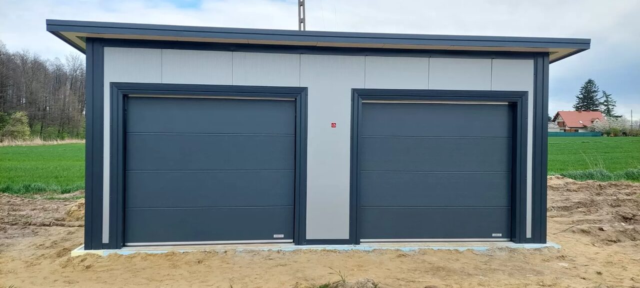 Grey insulated PIR double garage with two anthracite sectional doors, straight front view