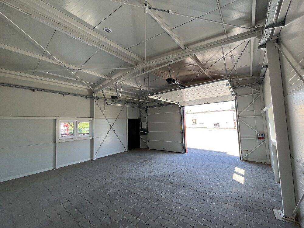 Insulated garage interior looking out through the open sectional door, white PIR panels
