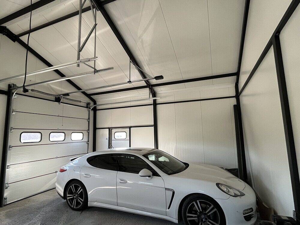 Insulated apex garage interior with a car parked inside, white PIR panels in bright daylight
