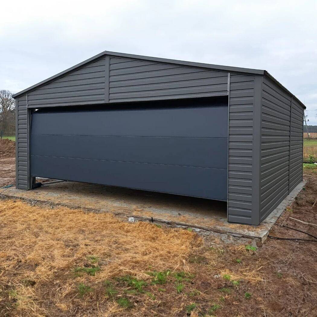 Anthracite steel garage with mono-pitch roof, front three-quarter view on gravel